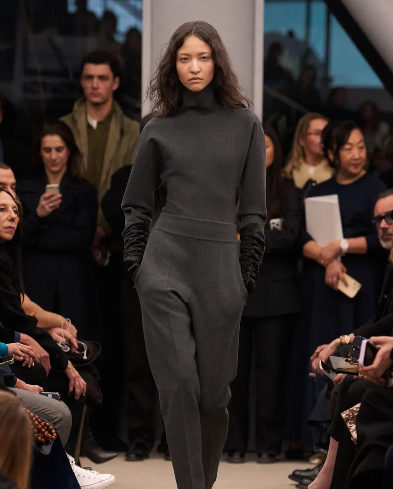 Alaïa FW2026 grå look i jersey med hög hals och långa svarta handskar