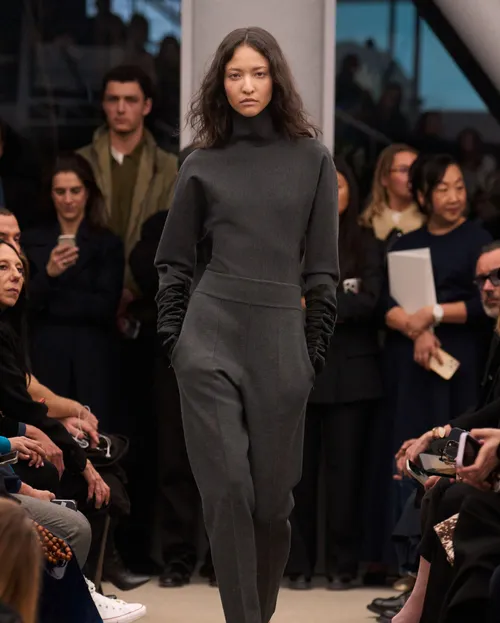Alaïa FW2026 grå look i jersey med hög hals och långa svarta handskar