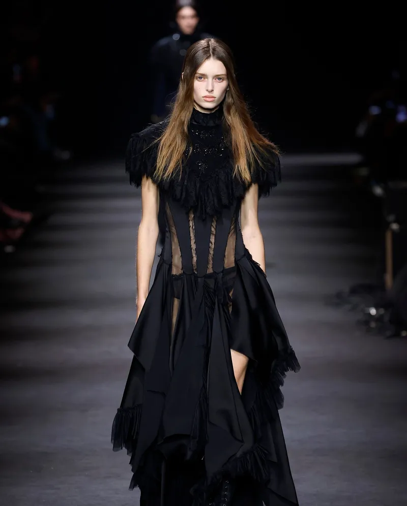 Ann Demeulemeester FW2026 svart klänning med spetskrage, transparent korsettliv och asymmetrisk kjol
