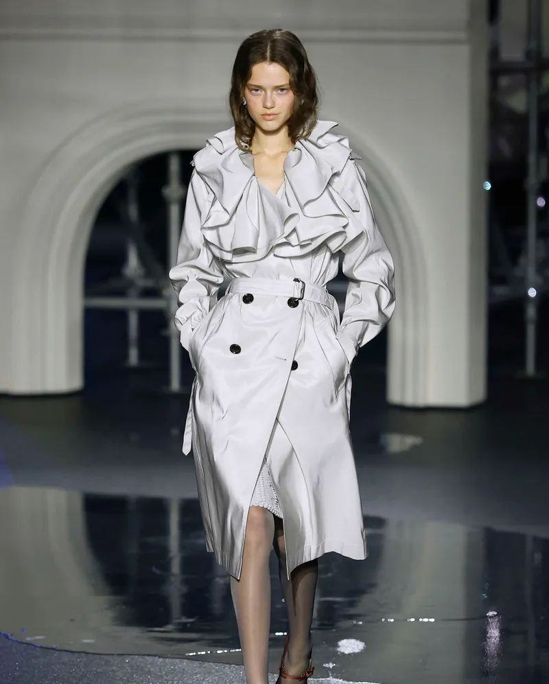 Burberry FW2026 elfenbensvit trenchcoat med volangkantade axelslejfar