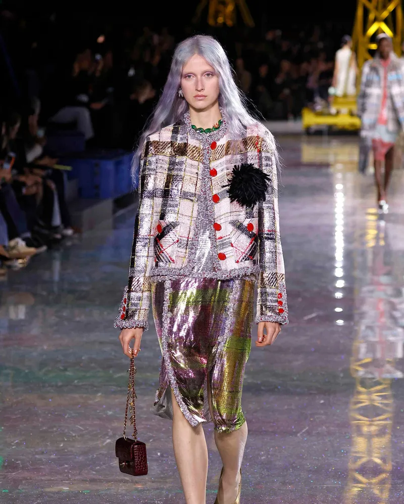 Chanel FW2026 skimrande rutig jacka med röda knappar och iriserande metallkjol