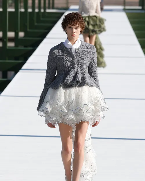 Dior FW2026 grå stickad kofta med peplum över vit tyllkjol