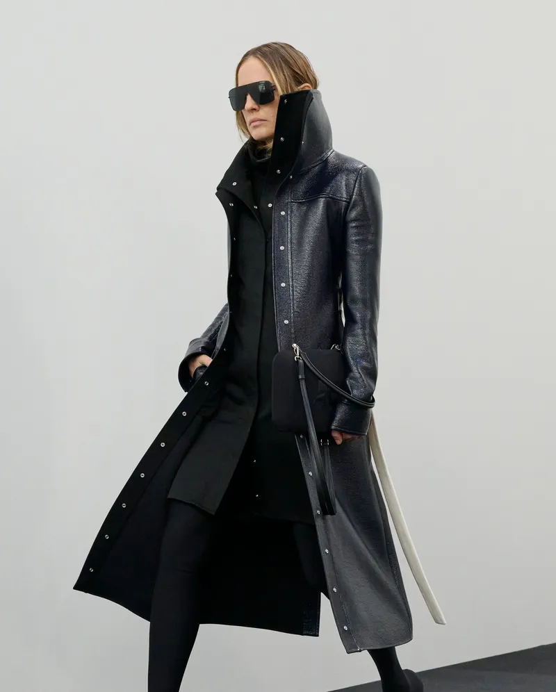 Courrèges FW2026 lång svart kappa med uppfälld trattkrage