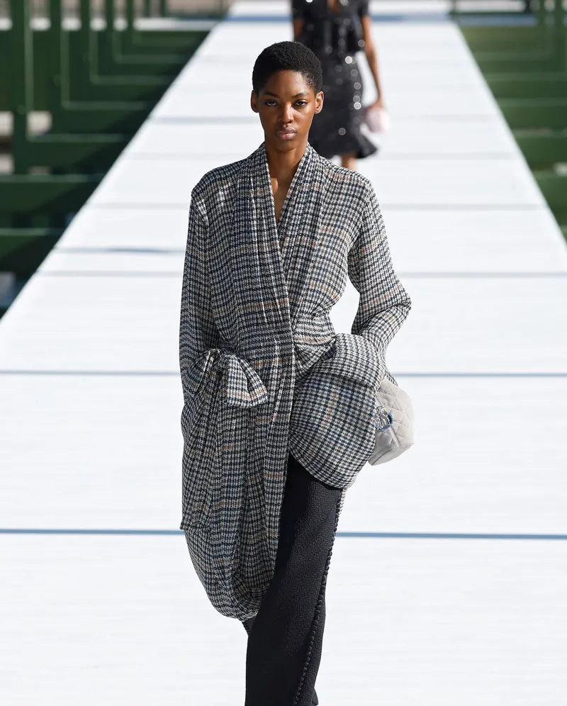 Dior FW2026 grårutig omlottkappa till svarta byxor