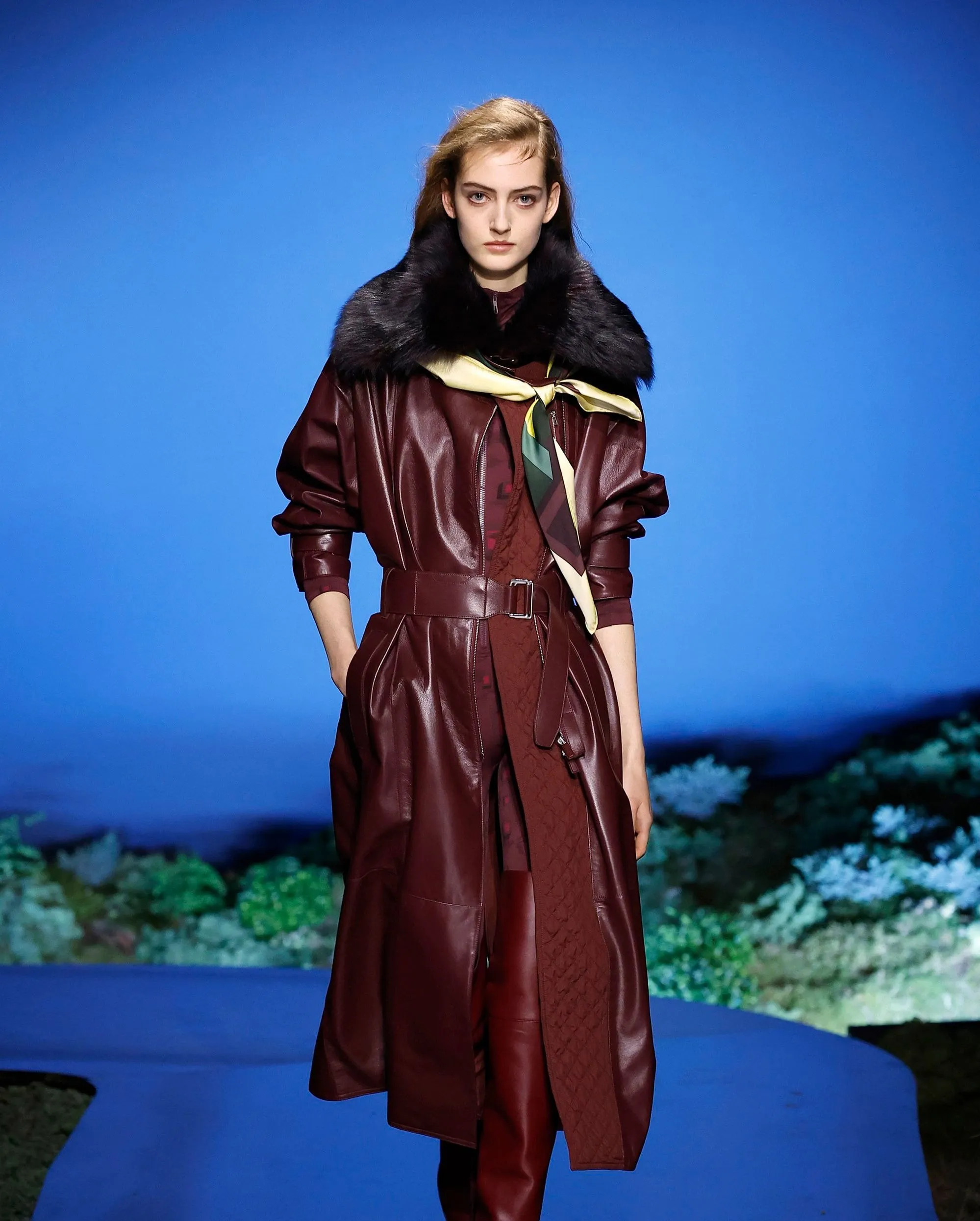Hermès FW2026 vinröd läderkappa med skärp och mörk pälskrage