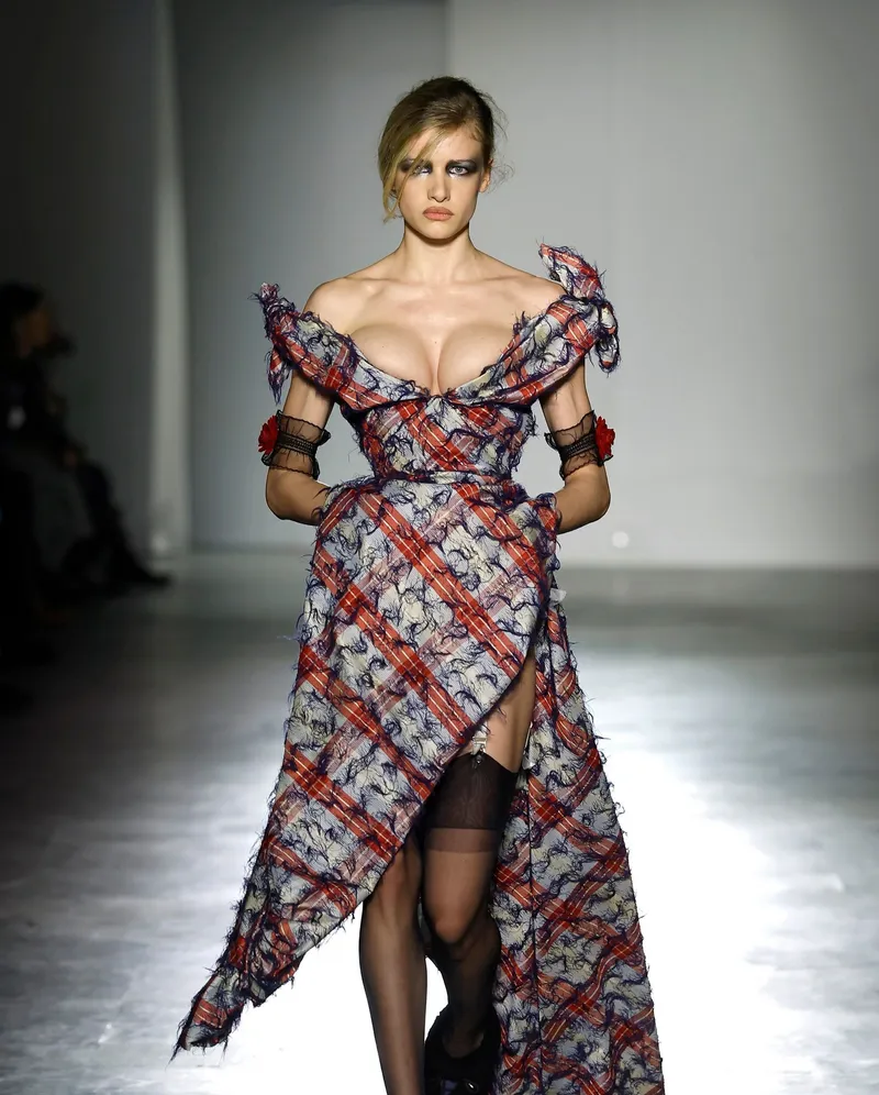 Andreas Kronthaler for Vivienne Westwood FW2026 urringad rutig klänning med blå trådtofsar, hög slits och nylonstrumpor